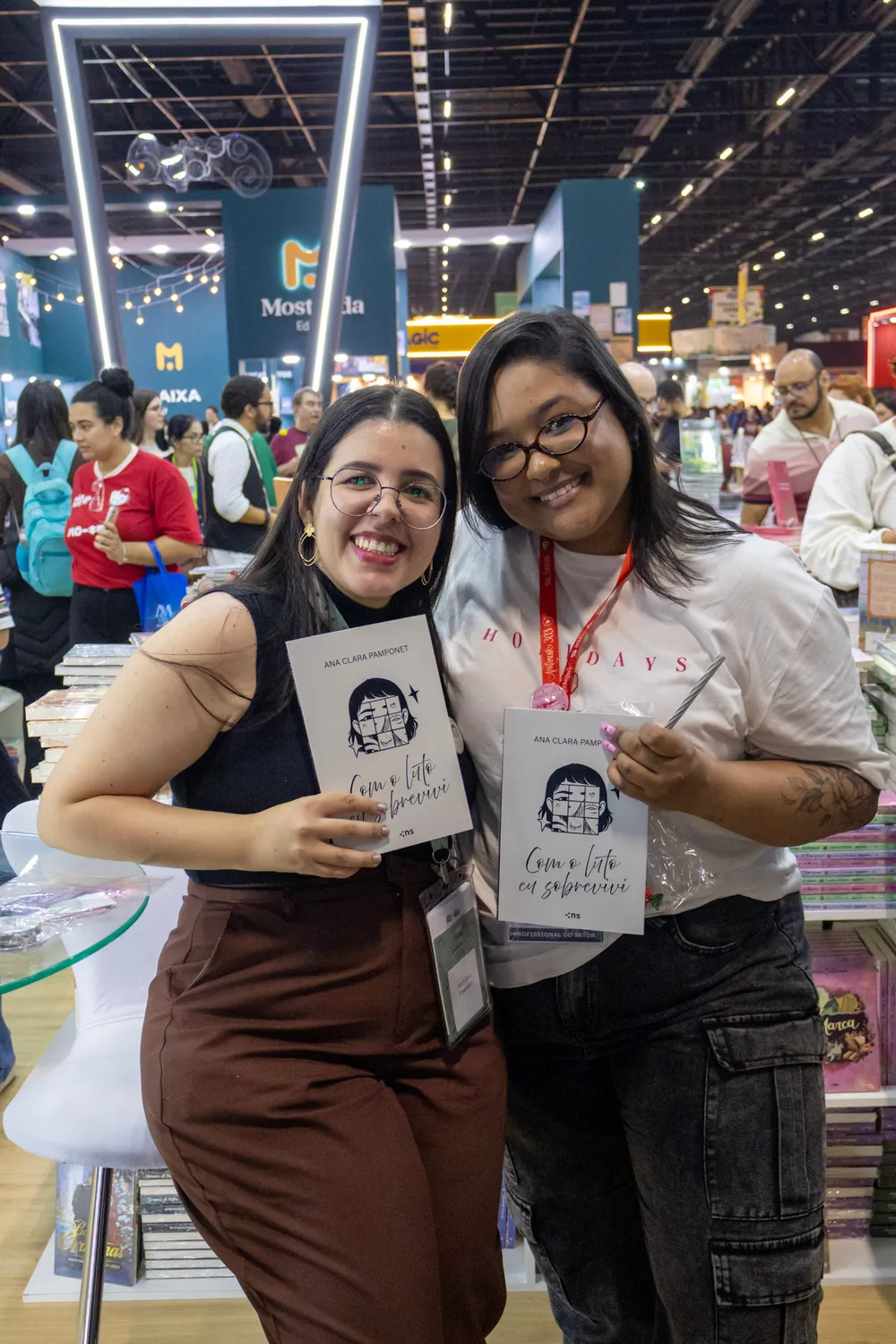 Ana Clara Pamponet com uma leitora e exemplares autografados